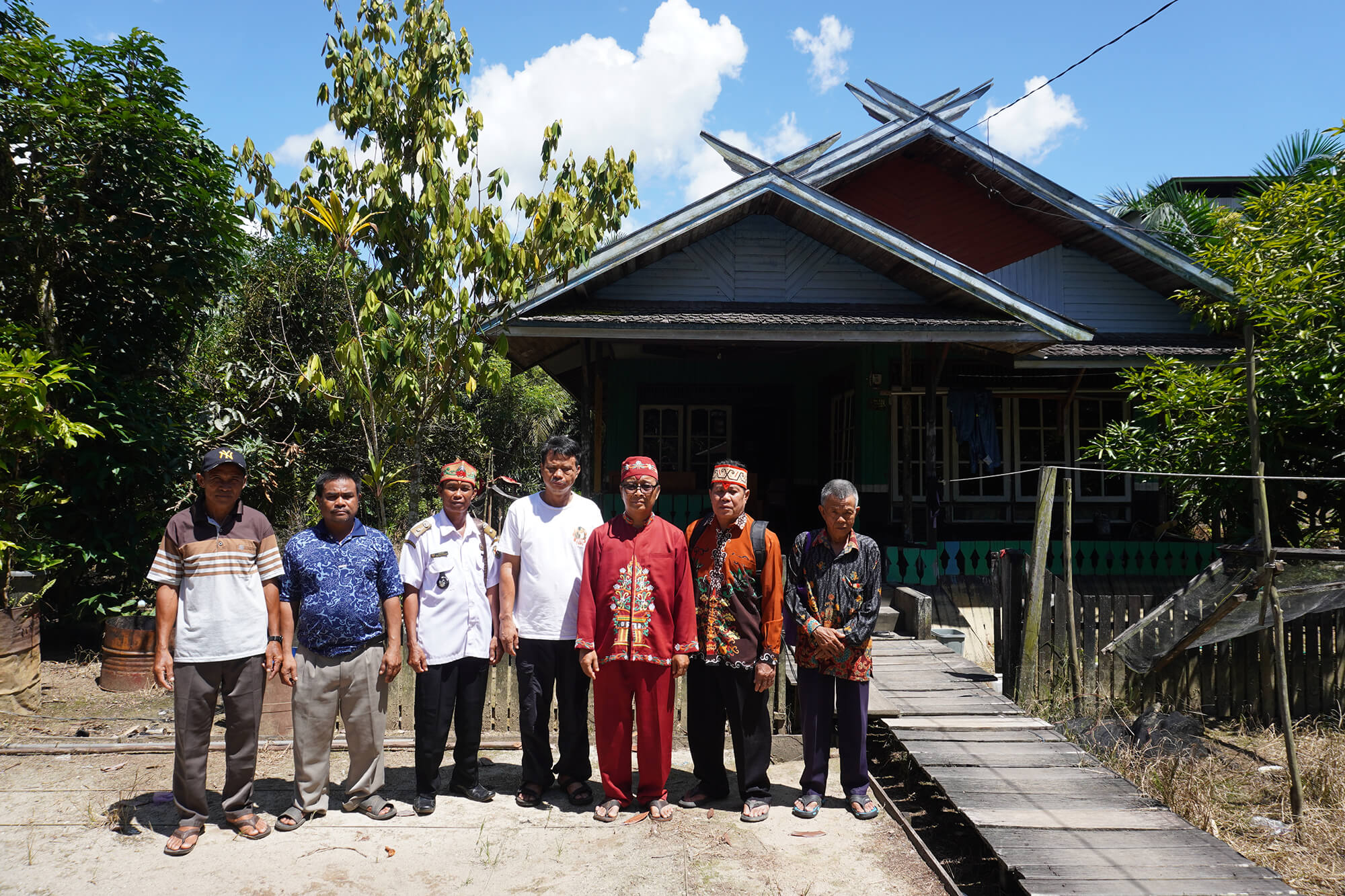 Elders Hardianto (third right) and Dobe (second right) of the Ngaju community, one of the largest Dayak subtribes, pose on April 29 with Petak Bahandang village chief Eman (third left) and other members of the tribe in front of a Dayak traditional house in the village, Tasik Payawan district, Katingan regency, Central Kalimantan.