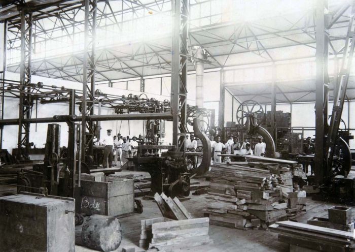 Pekerja dan bahan yang terlihat di dalam sebuah bangunan Artillerie Constructie Winkel di Bandung pada tahun 1925. (Koleksi Tropenmuseum / Museum of the Tropics, Amsterdam)